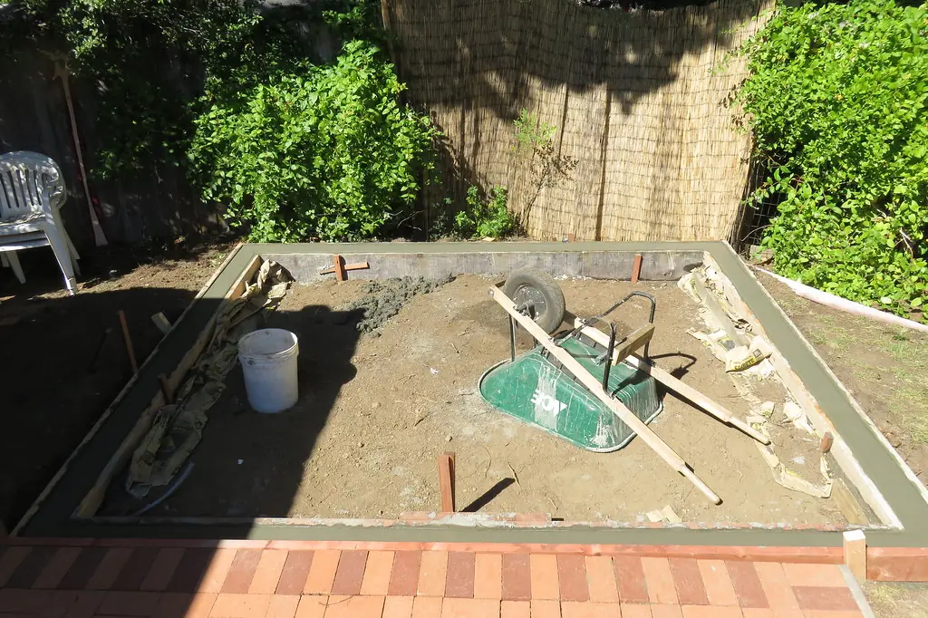 Concrete placed along the forms of a small backyard slab with the middle still to fill