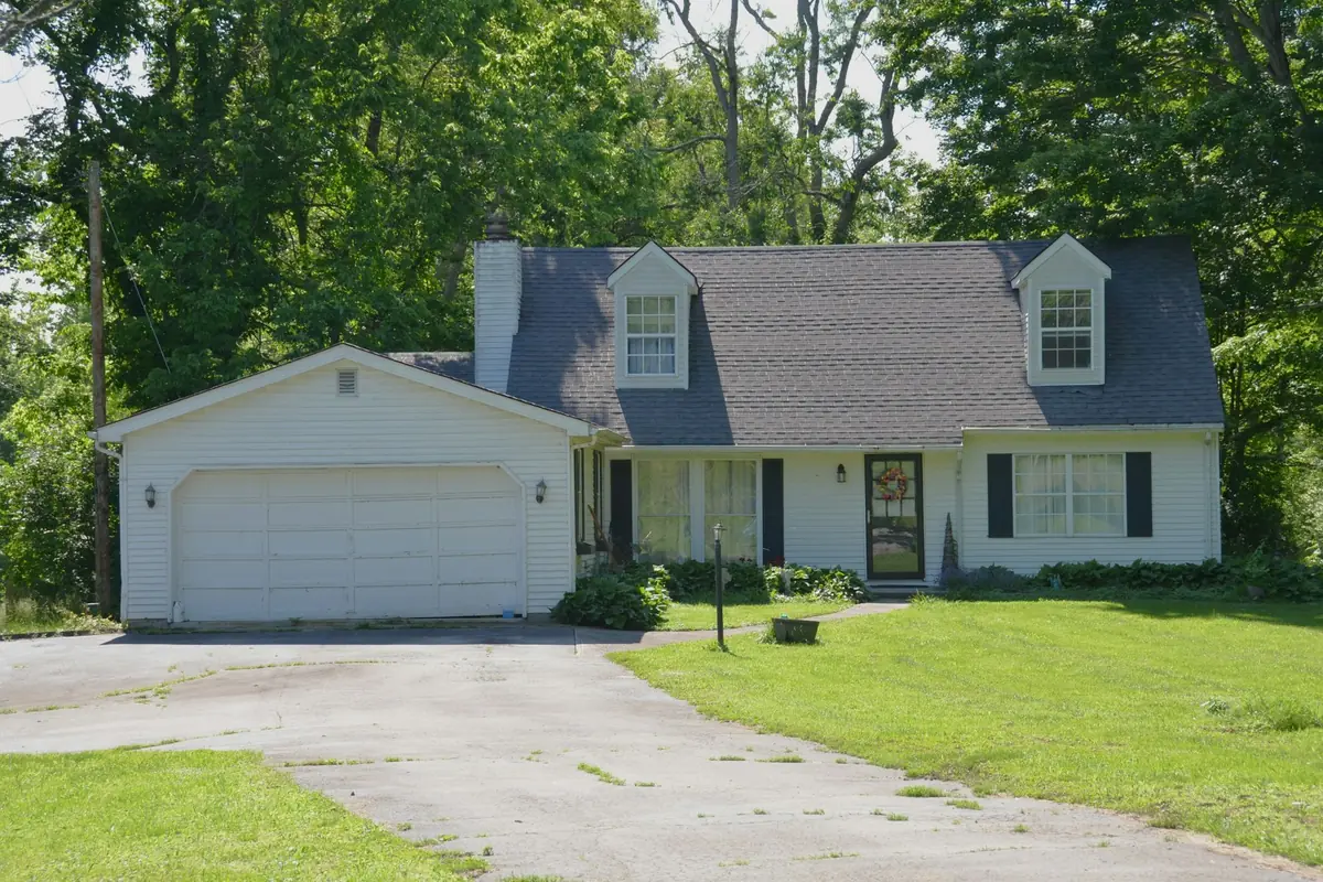 White house with an attached two-car garage and a long concrete driveway