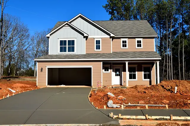 Freshly poured concrete driveway in front of a new two-story house