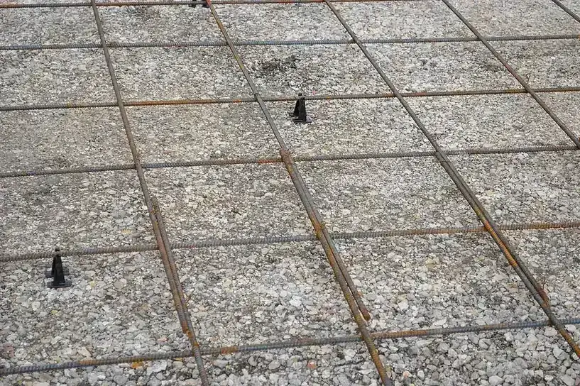 Rebar grid tied over a gravel base with plastic chairs under the bars