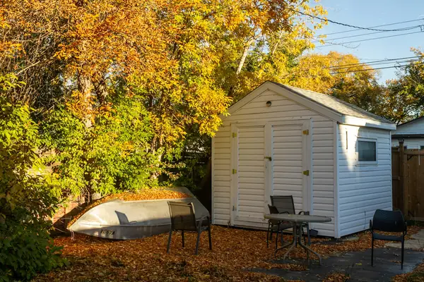 White vinyl shed beside a sitting area